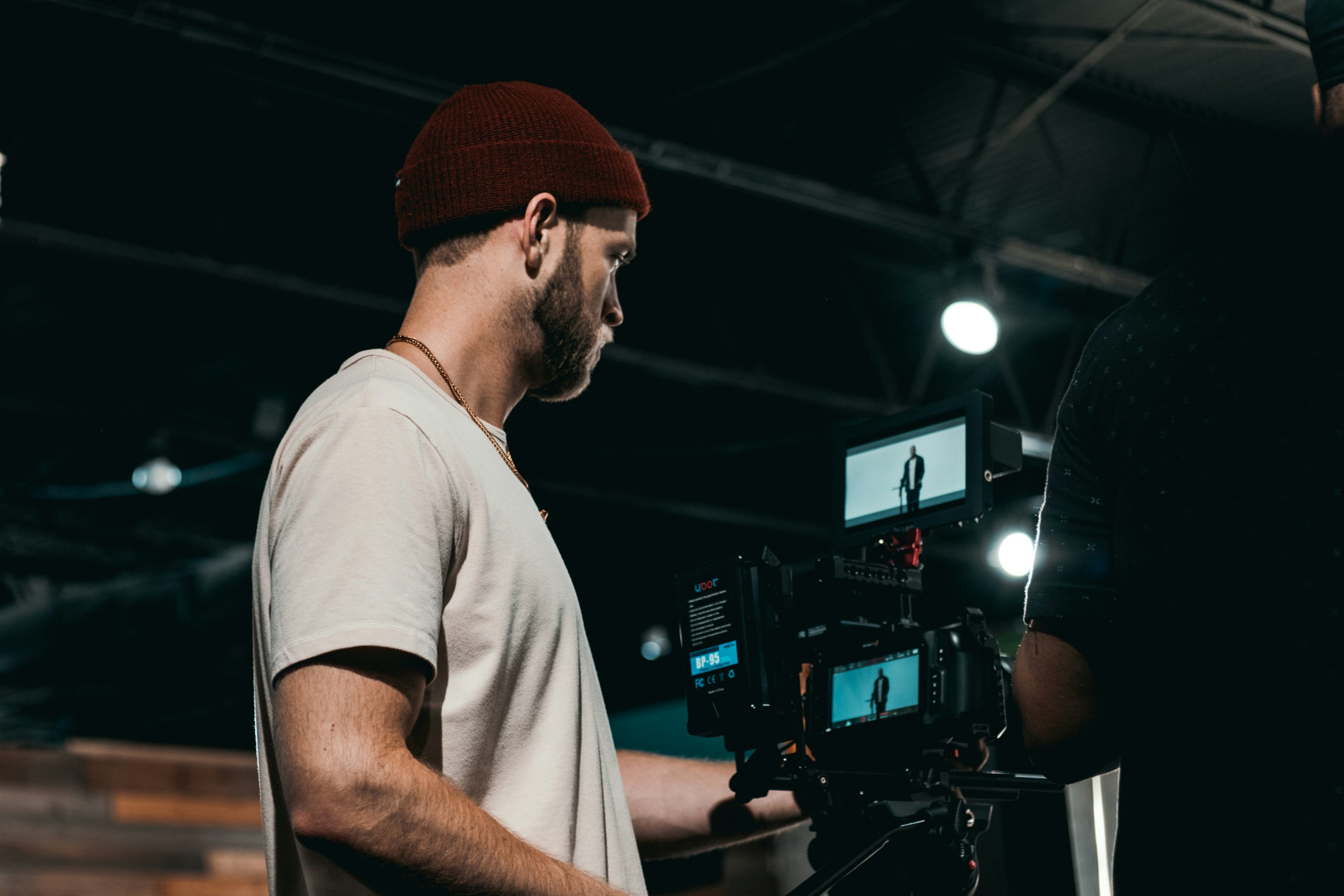 Videoproduzent mit professioneller Kameraausrüstung beim Dreh in einem Studio
